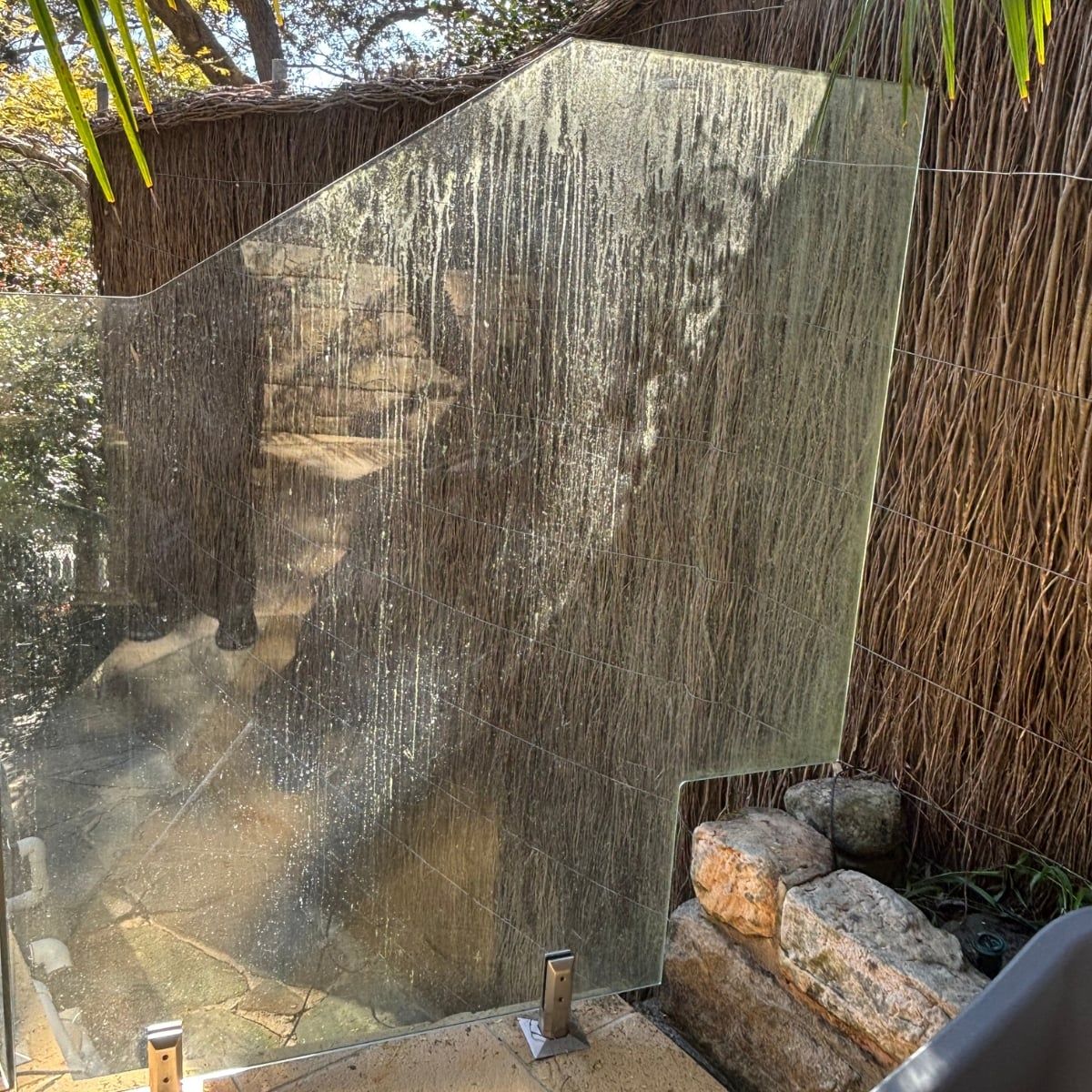 Pool glass fencing with water spots and grime before cleaning in Sydney